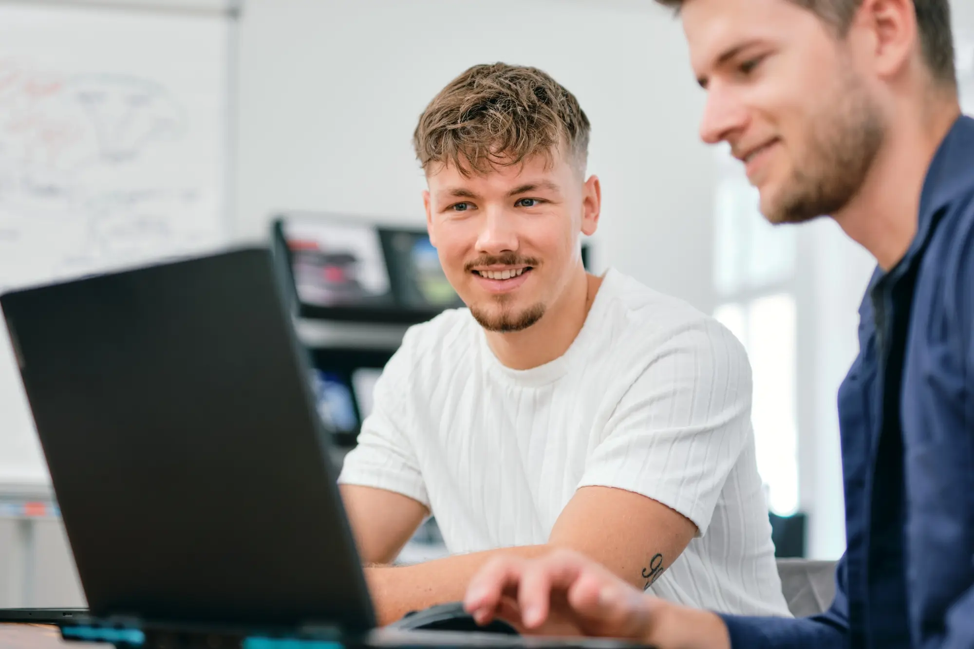 Mitarbeitende besprechen Social-Media-Inhalte am Laptop