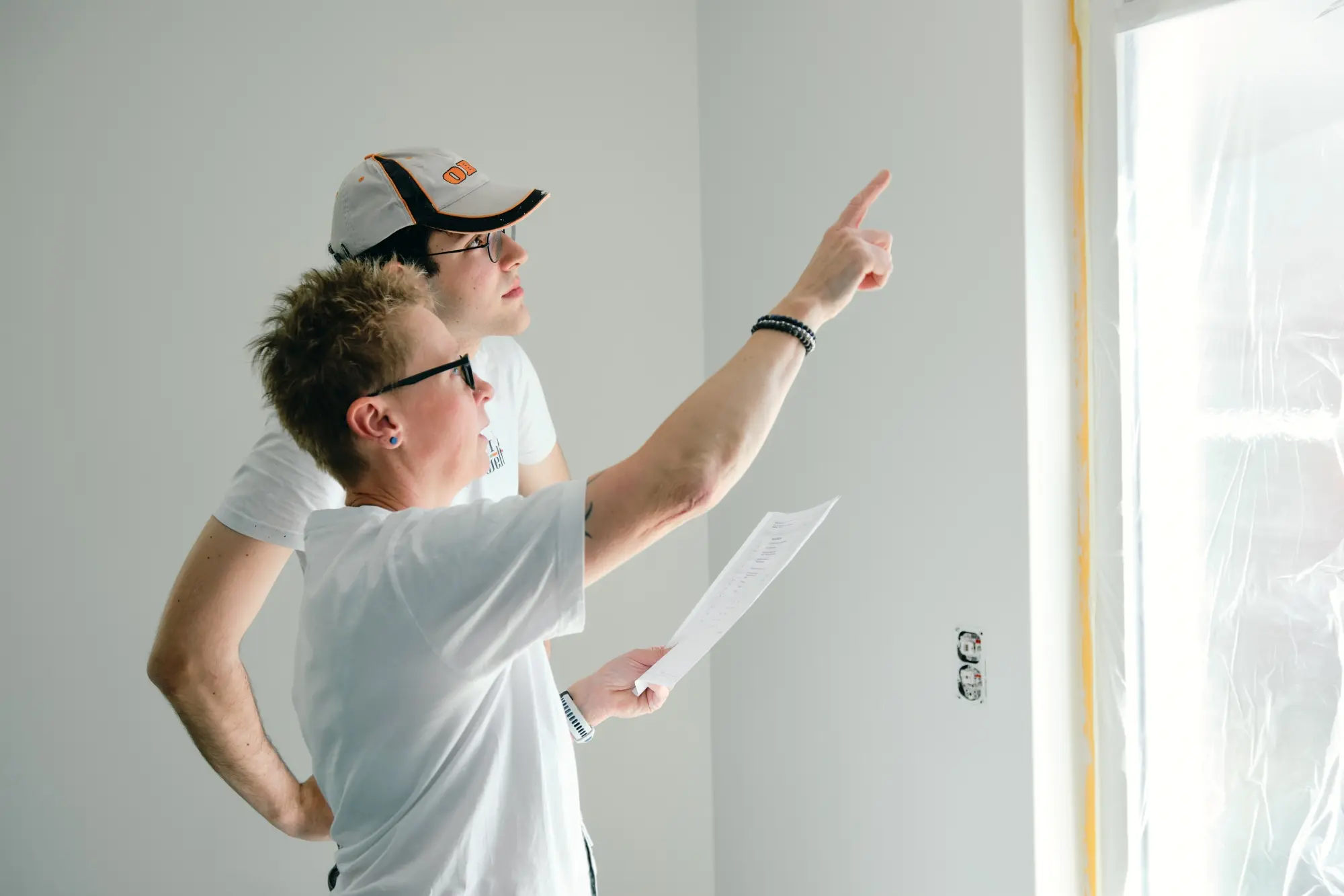 Maler zeigt auf eine frisch gestrichene Wand