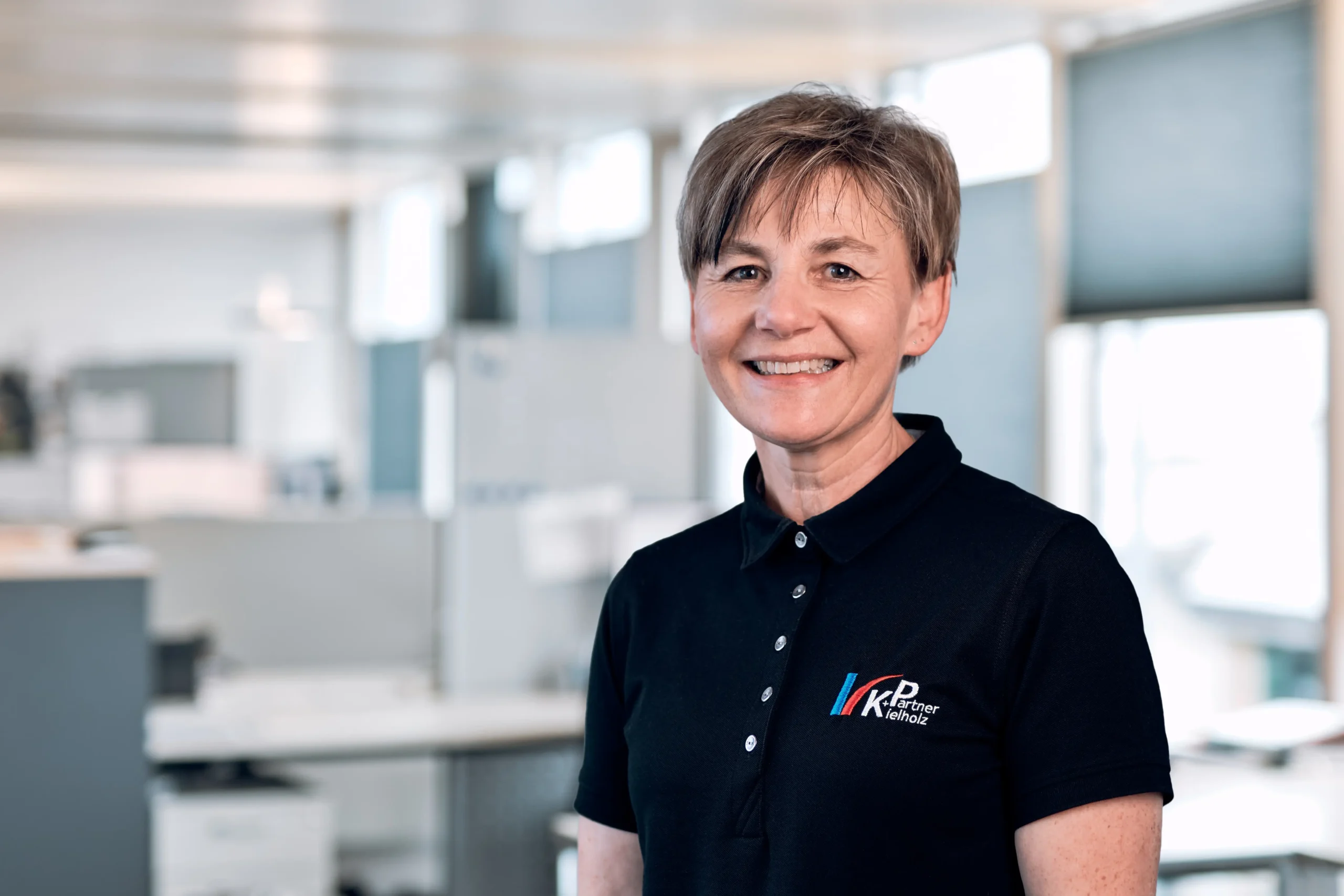 Mitarbeiterin im Portrait am Arbeitsplatz