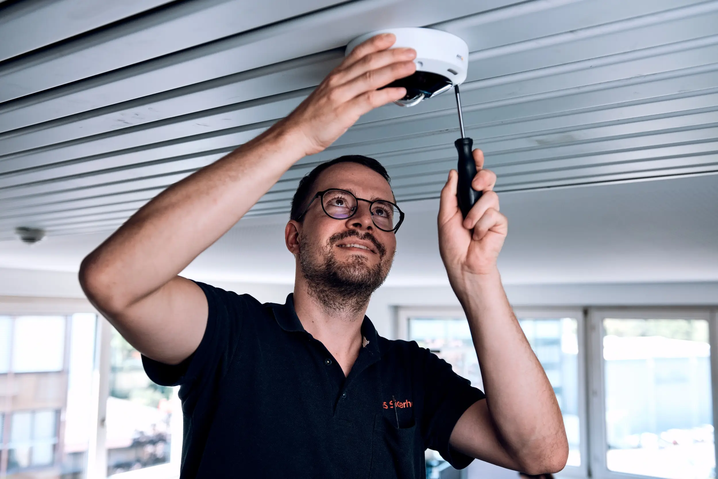 Techniker montiert einen Rauchmelder an der Decke