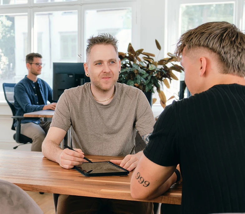 Kundengespräch mit Tablet am Bürotisch